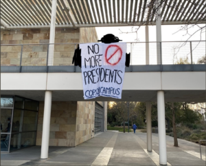 banner drop at the Mondavi Center reading "No More Presidents/Cops Off Campus"