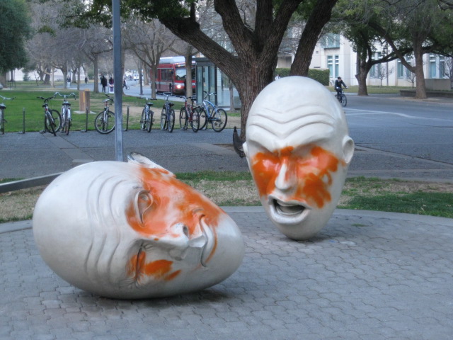 egghead statues decorated with orange spray paint