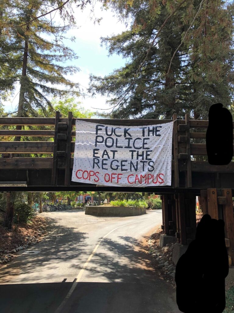 Banner reading "Fuck the police/Eat the Regents/Cops Off Campus" dropped from overpass on UC Davis campus